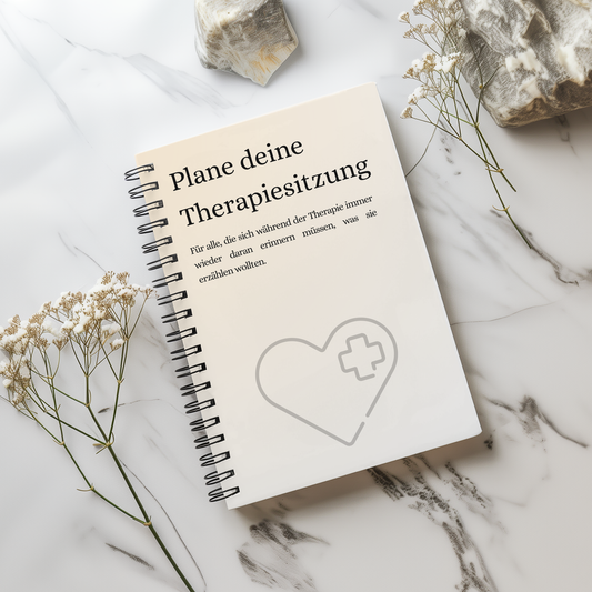 Therapieplaner „Plane deine Therapiesitzung“ als Spiralbuch auf hellem Marmor mit Trockenblumen, für Notizen vor der Therapiesitzung.