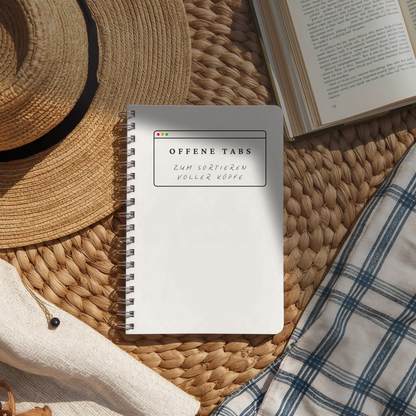 „Offene Tabs“ Journal als Spiralbuch auf geflochtener Unterlage mit offenem Buch und Strohhut, zum Sortieren voller Köpfe.