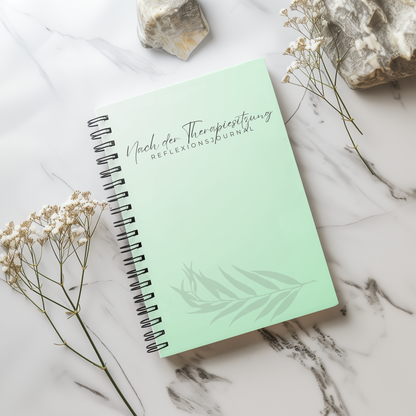 Mintgrünes Reflexionsjournal „Nach der Therapiesitzung“ als Spiralbuch auf hellem Marmor mit Trockenblumen.
